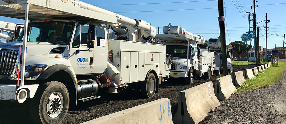 OUC utility trucks line up for shipment from Jacksonville to Puerto Rico